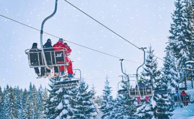 Kayakçı ve snowboard üzerinde bir teleferik
