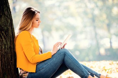 Güzel kız parkta tablet dışında kullanma. iş, eğlenceli, keyifli zaman