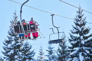 Kayakçı ve snowboard üzerinde bir teleferik