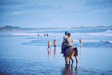 insanlar bir at nalı batımında, Endonezya bali beach üzerinde sürme