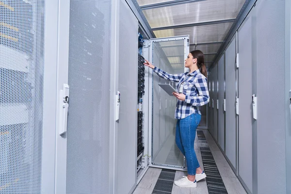 female technician working on server maintenance in white server room