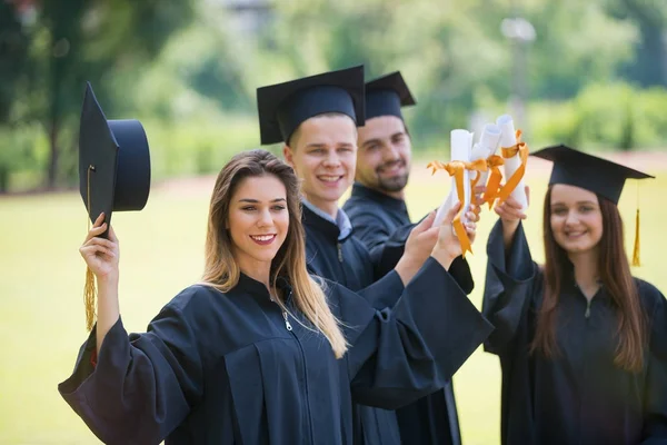 毕业和人的概念 一群穿着滑雪板和有文凭的学士礼服的快乐的国际学生 — 图库照片