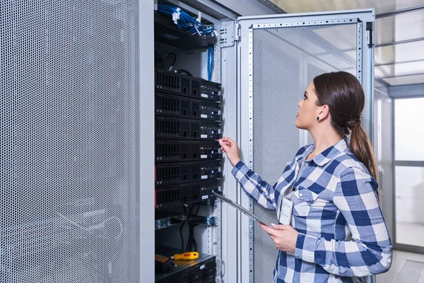 female technician working on server maintenance in white server room