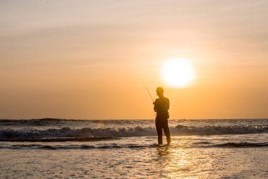 Adam akşam sahildeki Balık tutma