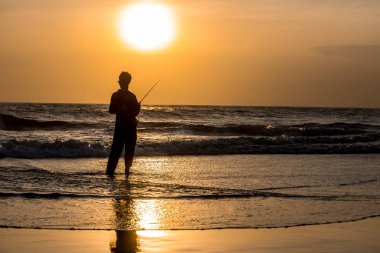 Adam akşam sahildeki Balık tutma