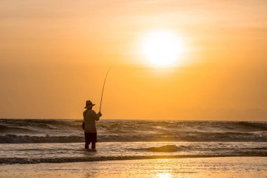 Adam akşam sahildeki Balık tutma