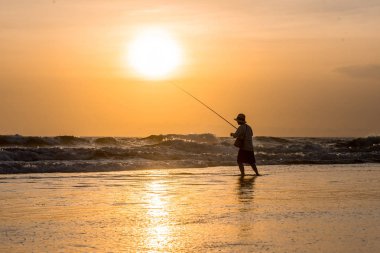 Adam akşam sahildeki Balık tutma
