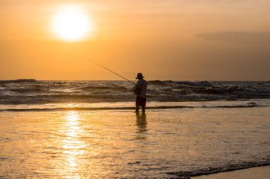 Sahilde balık tutan adam.