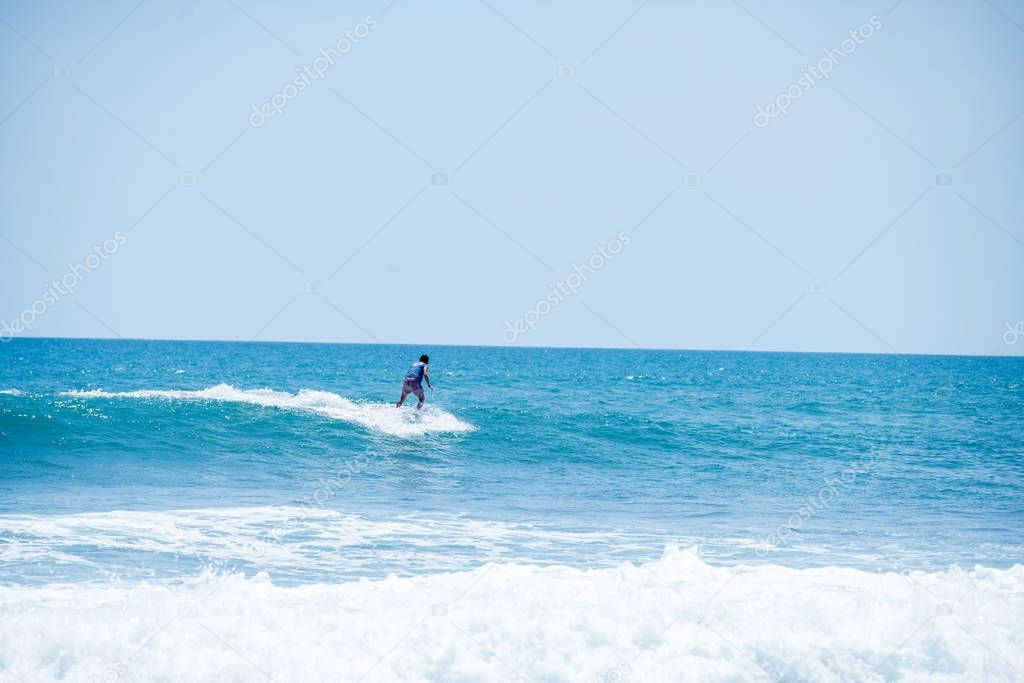 Surfing the waves of Indonesia beach. vacation concept