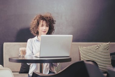 Dizüstü bilgisayar kullanan bir caffe kız
