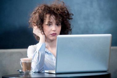 Dizüstü bilgisayar kullanan bir caffe kız