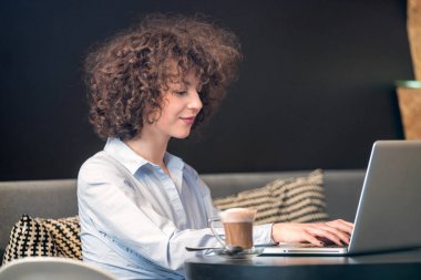Dizüstü bilgisayar kullanan bir caffe kız