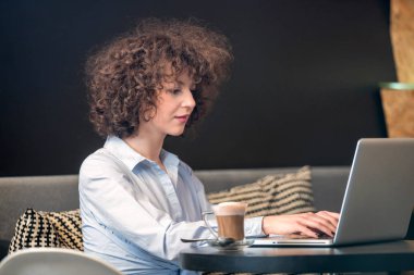 Dizüstü bilgisayar kullanan bir caffe kız