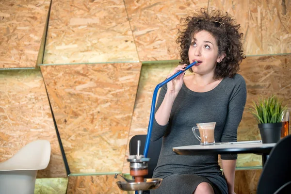 Trendiga hipster flicka njuter vattenpipa på ett modernt kafé — Stockfoto