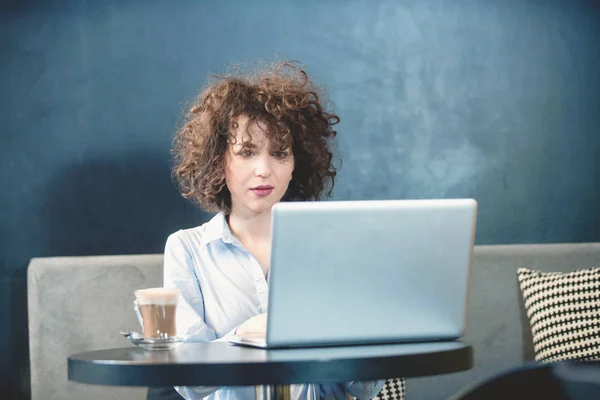 Flicka med laptop på en caffe — Stockfoto