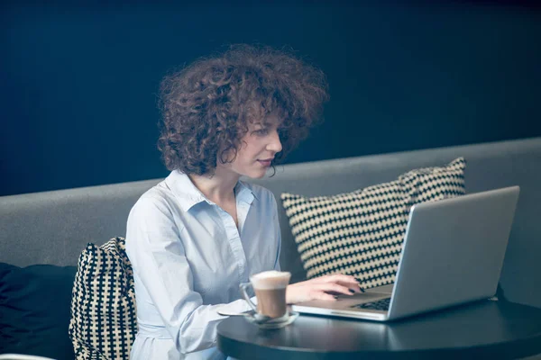 Flicka med laptop på en caffe — Stockfoto