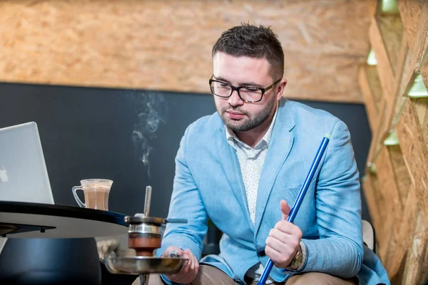 Guy smoking hookah at a coffee shop — Stock Photo, Image