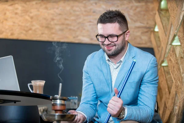 En fyr som røyker på en kaffebar. – stockfoto