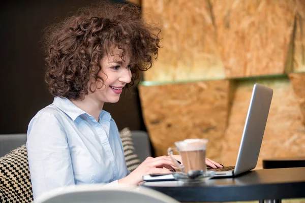 Flicka med laptop på en caffe — Stockfoto