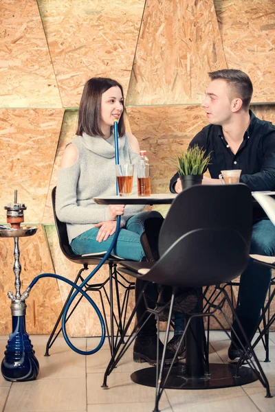 Пара расслабляющий и курение кальян в кафе-баре Стоковая Картинка