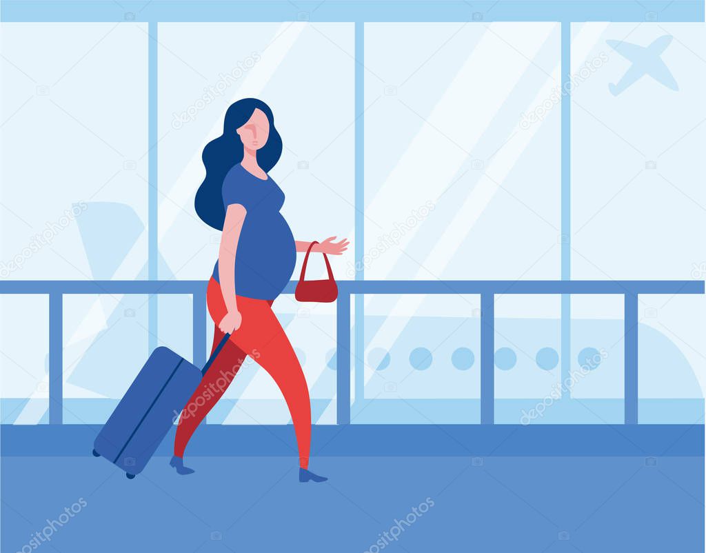 A pregnant woman with a suitcase is walking through the airport to Board a plane.