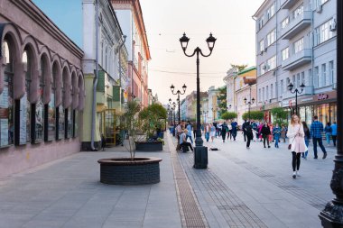 İnsanlar yazın akşamları şehrin sokaklarında yürürler..