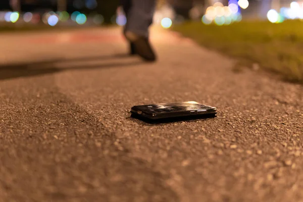 A man walks the road at night in the city