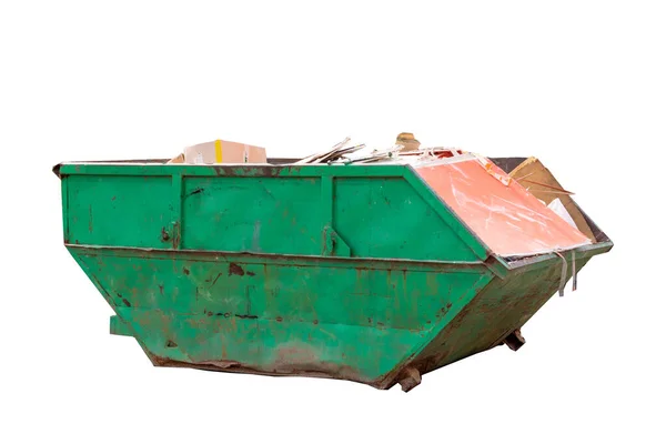Container for construction waste with broken bricks on the background of a multi-storey building