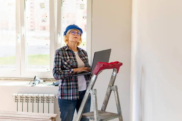 Mujer Constructora en la habitación de la casa haciendo reparaciones . — Foto de Stock