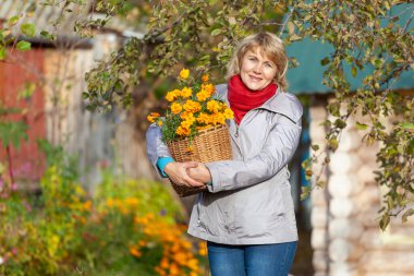 Bahçedeki kadın sebze hasat ediyor, meyvenin üstünde.