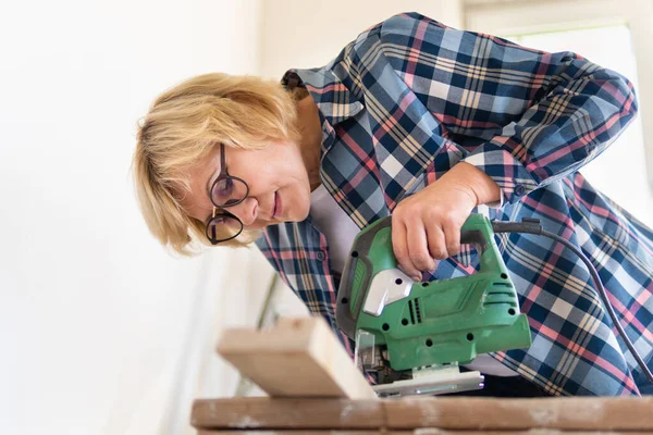 Bauarbeiterin im Zimmer macht Reparaturen. — Stockfoto