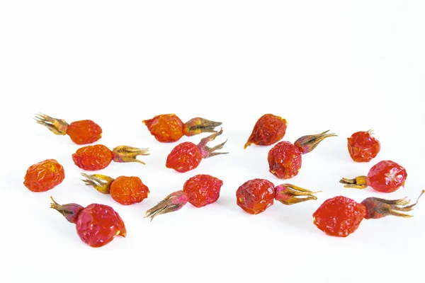 Ягоды из красных шиповников полезны для здоровья на белой поверхности — стоковое фото