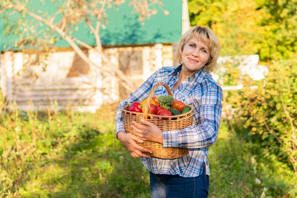 Wanita yang bekerja di kebunnya di tempat tidur sayuran dan bunga — Stok Foto