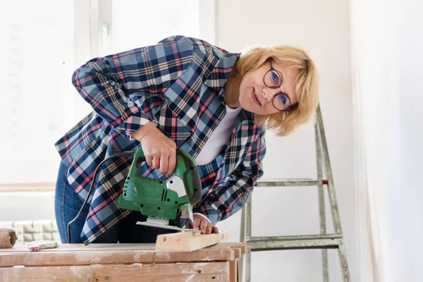 Bauarbeiterin im Zimmer macht Reparaturen. — Stockfoto