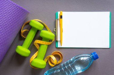 Koyu gri kağıt arkaplanda yeşil halterler .