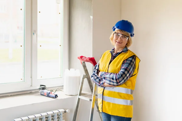 Mujer Constructora en la habitación de la casa haciendo reparaciones . — Foto de Stock