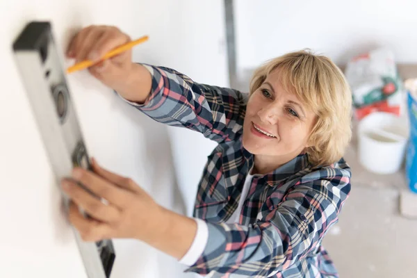 Bauarbeiterin im Zimmer des Hauses bei Reparaturen. — Stockfoto