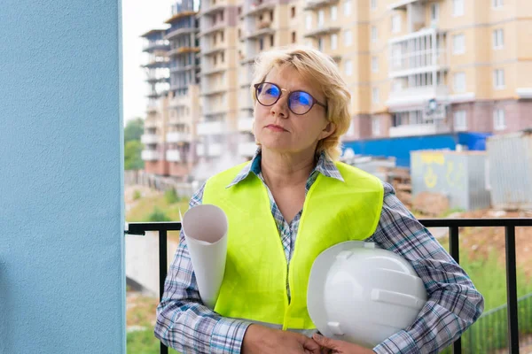 Eine Bauarbeiterin auf einer Baustelle arbeitet und steuert den Prozess. — Stockfoto