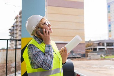 İnşaat alanında çalışan bir kadın müteahhit süreci kontrol ediyor..