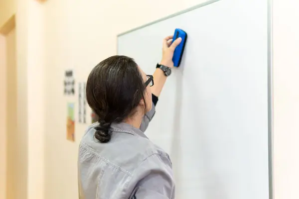 Женщина-предприниматель или учитель, пишущая на доске с стираемым маркером для презентации в конференц-зале . — стоковое фото