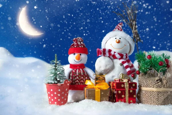 Yılbaşı ve yeni yıl hediyeleriyle kar yığınında bir kardan adam