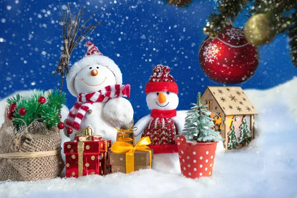 Yılbaşı ve yeni yıl hediyeleriyle kar yığınında bir kardan adam