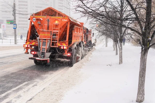 Um grande limpa-neves remove a neve da estrada — Fotografia de Stock