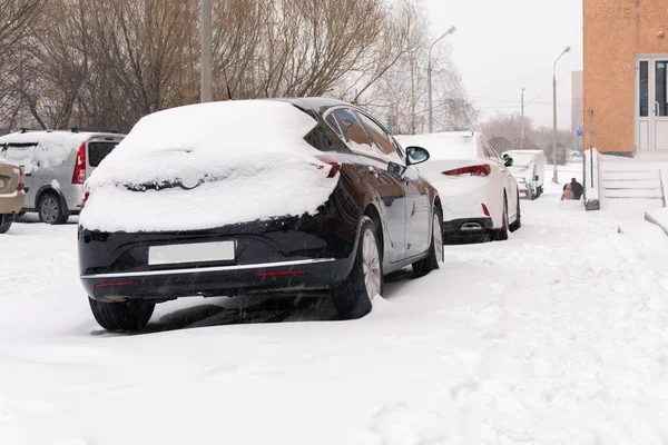 Snowfall w samochodach miejskich w śniegu na ulicy — Zdjęcie stockowe