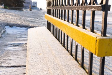 Buzlu bir yağmurdan sonra, sarkıtlar çitlerde ve banklarda asılı kalır..