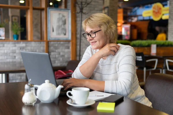 Una Mujer Trabaja Una Laptop Café Mujer Mediana Edad Bebiendo — Foto de Stock