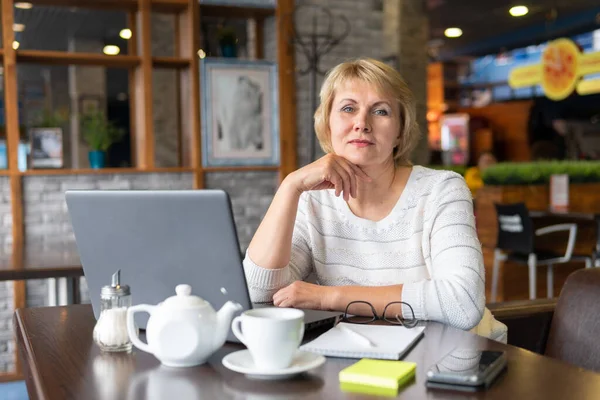 Una Mujer Trabaja Una Laptop Café Mujer Mediana Edad Bebiendo — Foto de Stock