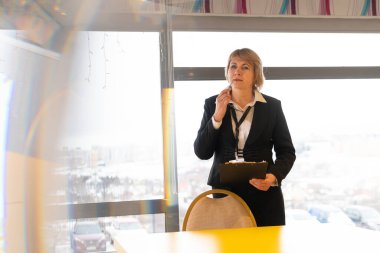 Bir kadın bir iş merkezinde eğitim veriyor. Orta yaşlı bir kadın, işletme stili yönetim kurulunda koçluk yapıyor..