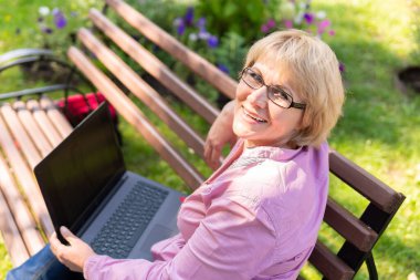 Bankta dizüstü bilgisayarda çalışan bir kadın. Orta yaşlı bir kadın sosyal medyada haberleri izliyor. İnternette çalışıyor..