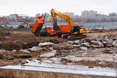 Vakıf için zemin kazmak ve kanalizasyon boruları döşemek için toprak kazmak. Dünyayı yerinden oynatan ağır ekipmanlar